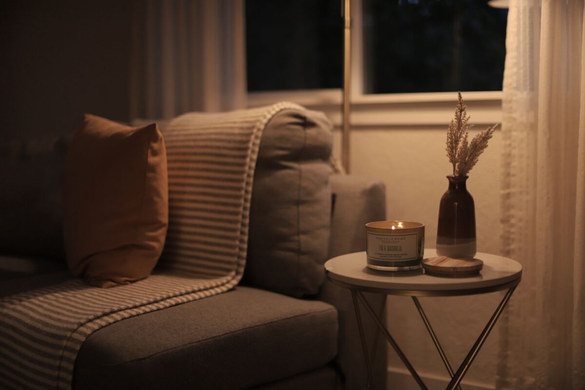 Warm, calm living room with a sofa and a lit candle