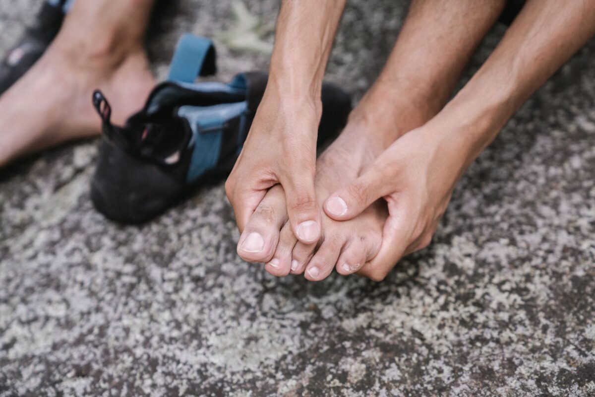 Person massaging their own bare feet with both hands