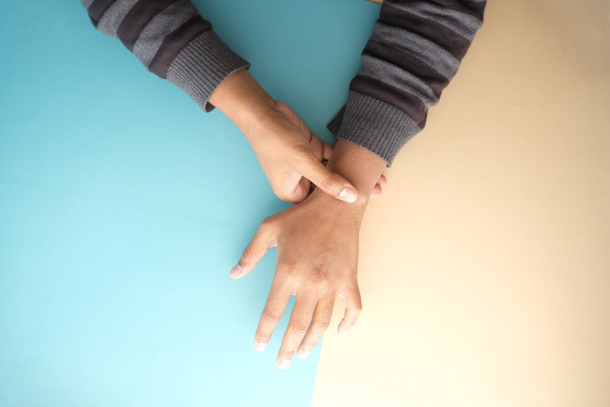 One hand resting on the opposite forearm and wrist