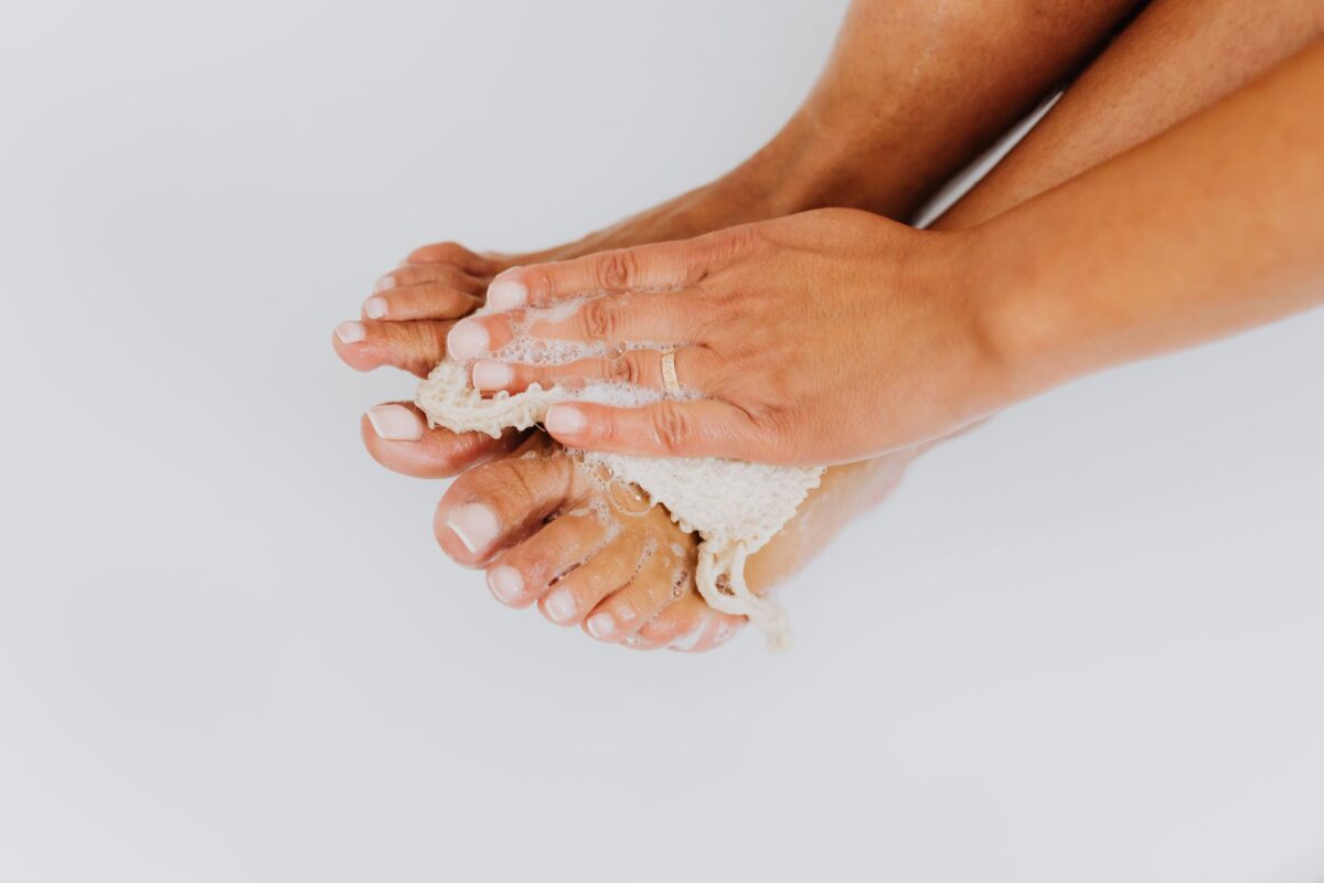 Hands gently washing a pair of feet