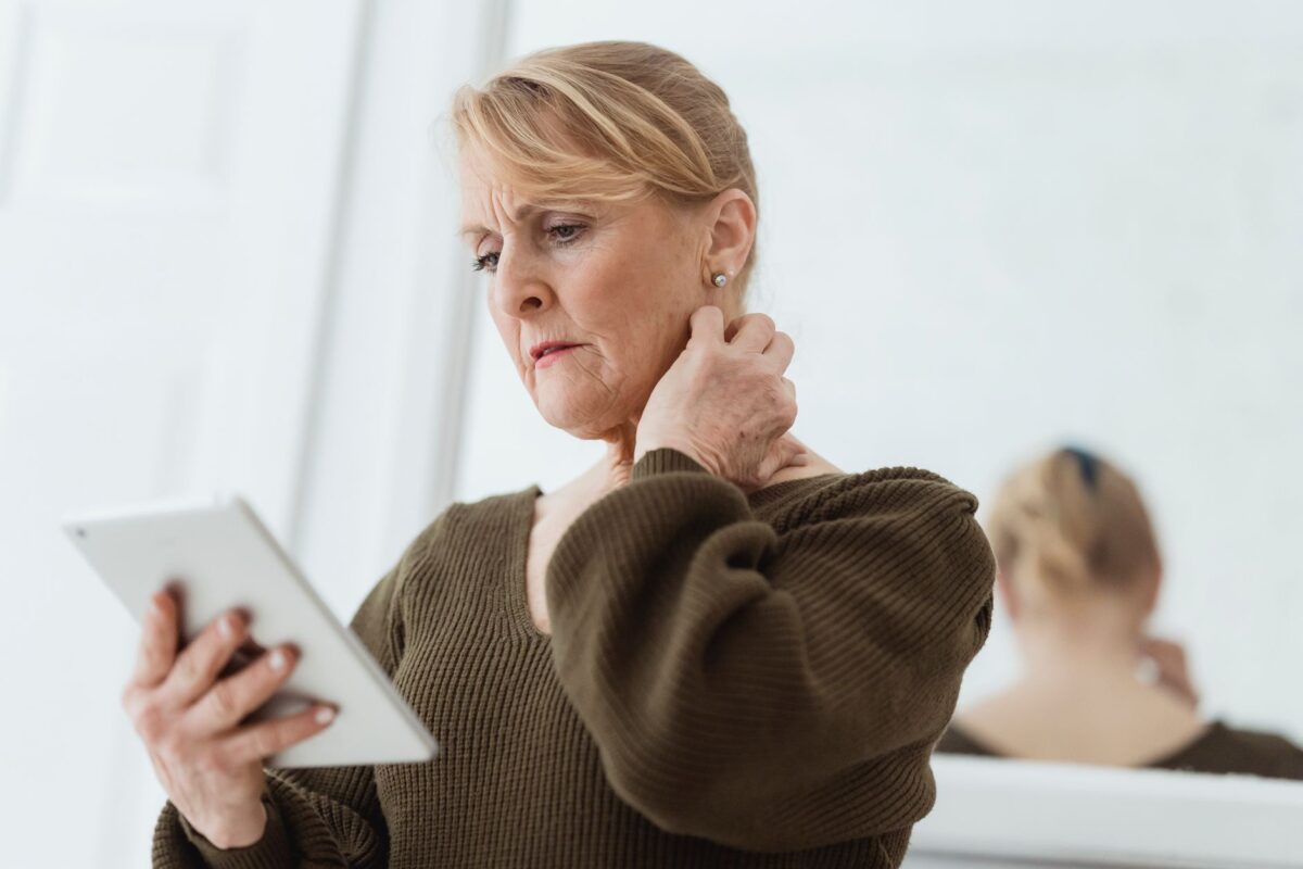 Woman gently rubbing the back of her neck with one hand
