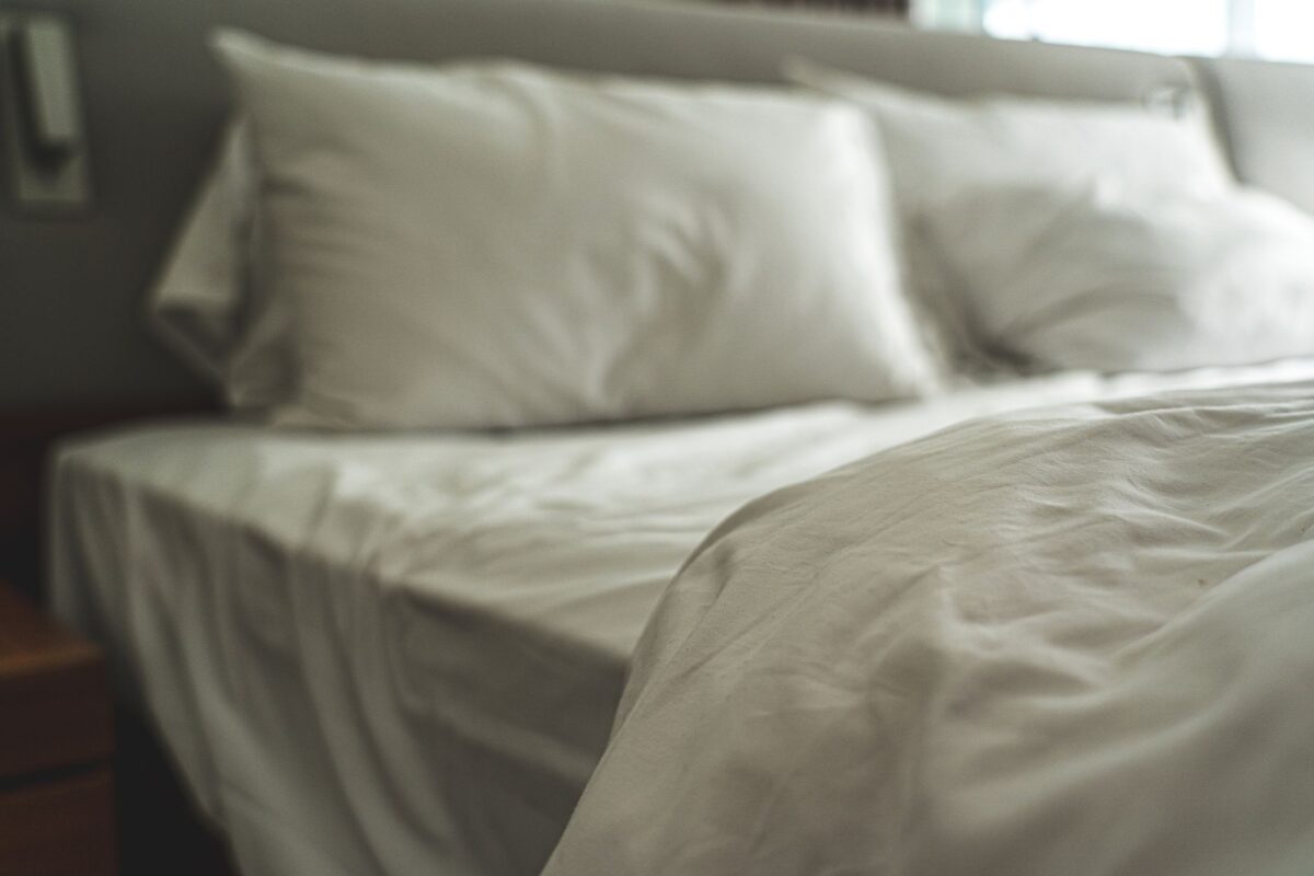 Clean white bed linen and soft pillows in soft light