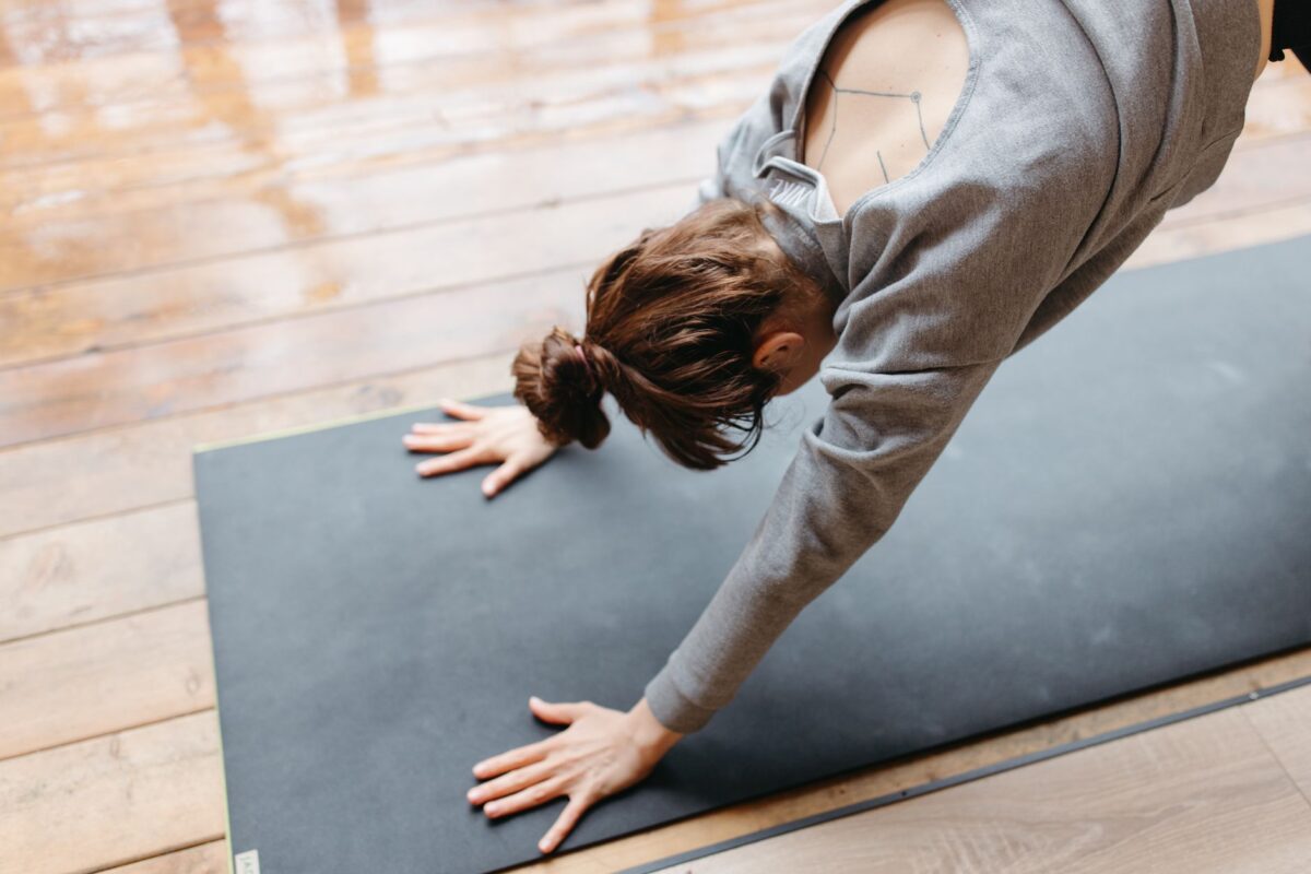 Woman doing a gentle stretch on a yoga mat at home